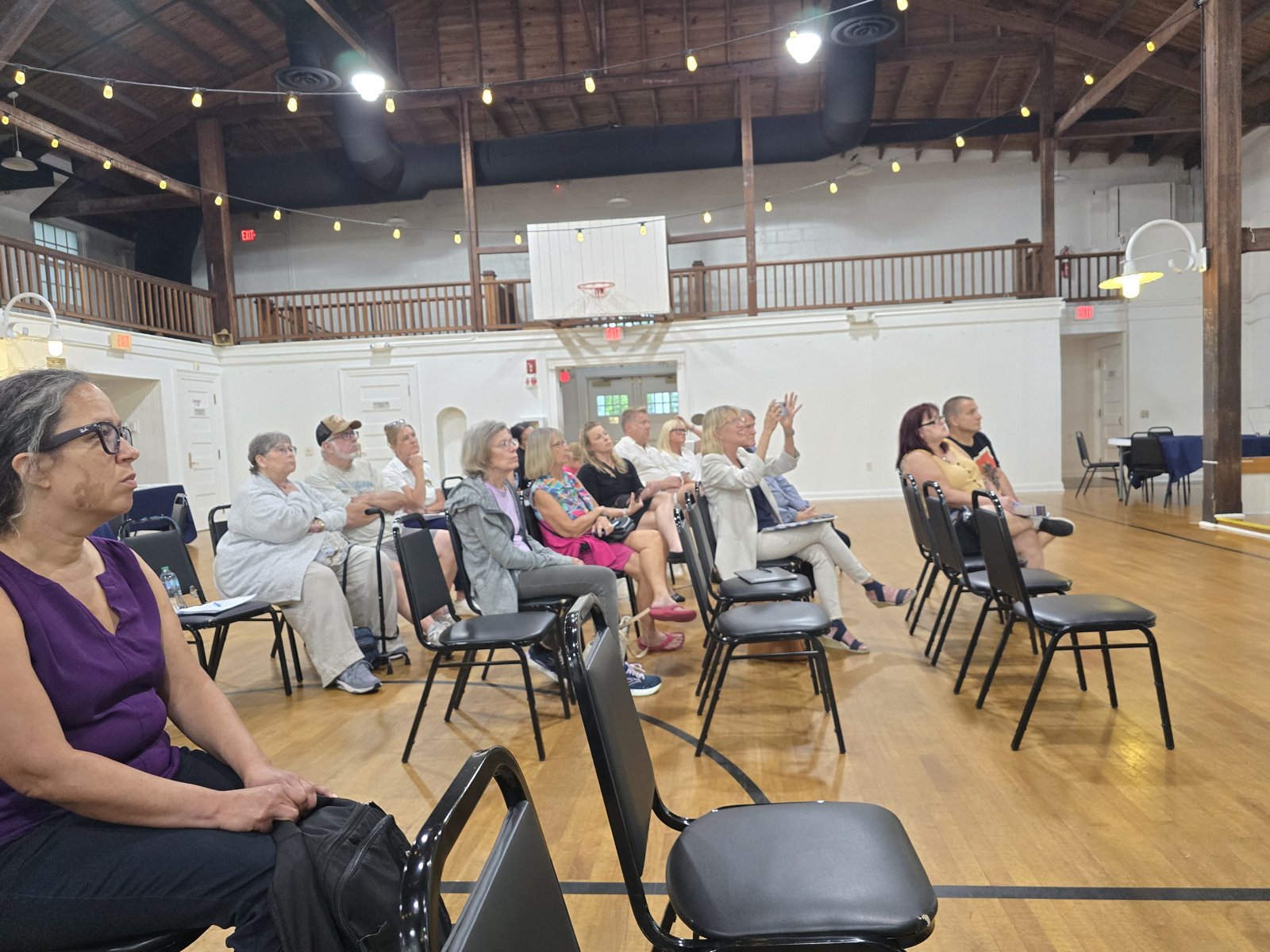 Community members listen to the meeting presentation.
